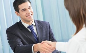 Real Estate Broker shakes hand with female client
