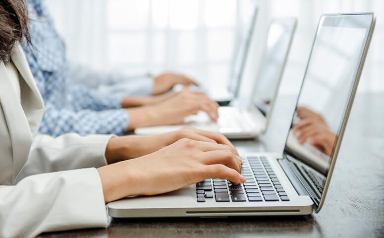 Three females working on three laptops