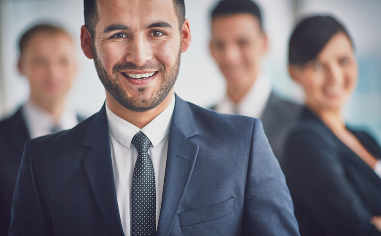 Smiling businessman with other team members in background